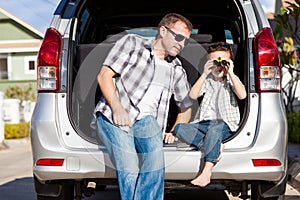 Happy father and son getting ready for road trip on a sunny day.