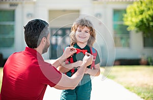 Happy father and son go to elementary school. Parent taking child to primary school. Positive human emotion.