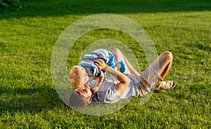 Happy father and son having fun outdoor on meadow