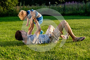 Happy father and son having fun outdoor on meadow