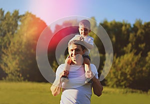 Happy father with son having fun outdoors, sunny summer day