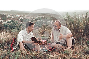 Happy father and son having a rest on nature on a summer day