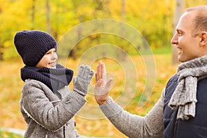 Happy father and son making high five in park