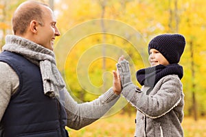 Happy father and son making high five in park