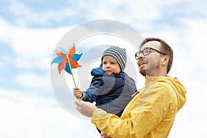 Happy father and son with pinwheel toy outdoors