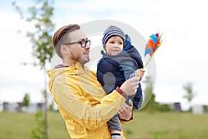Happy father and son with pinwheel toy outdoors
