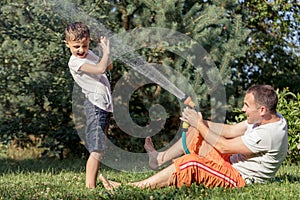 Happy father and son playing in the garden at the day time.