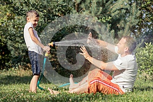 Happy father and son playing in the garden at the day time.