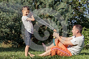 Happy father and son playing in the garden at the day time.