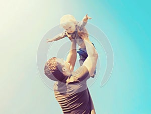 Happy father and son playing having fun together outdoors over sky