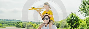 Happy father and son playing with toy airplane against old runway background. Traveling with kids concept BANNER, LONG FORMAT