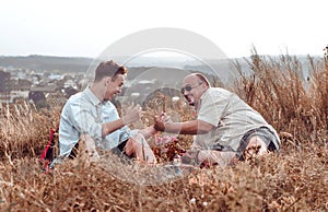 Happy father and son resting on nature in the evening