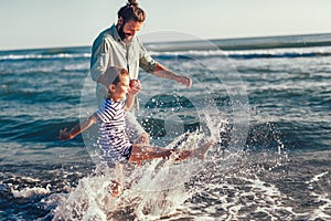 Happy father and son running and having fun in the beach