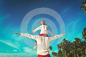 Happy father and son on shoulders play at sky