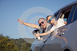 Happy father and son sitting in the car at the day time