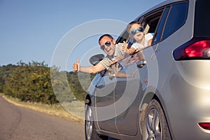 Happy father and son sitting in the car at the day time