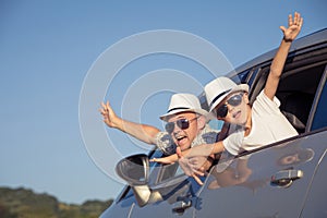 Happy father and son sitting in the car at the day time