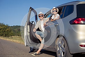 Happy father and son sitting in the car at the day time