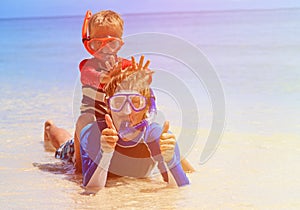 Happy father and son snorkeling on tropical beach