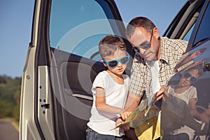 Happy father and son standing near the car at the day time