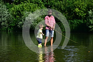 Happy Father and Son together fishing in summer day on the river. Anglers. Happy family concept - father and son