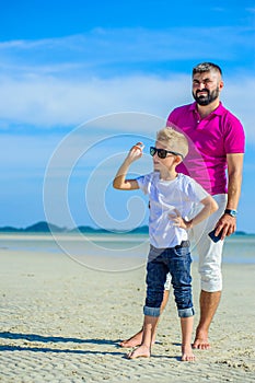 Happy father and son at the tropical beach, laughing and enjoing time together.