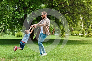 happy father spinning around son and they having fun