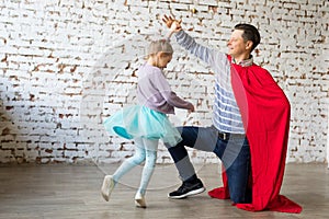 Happy father in superhero costume and his daughter photo