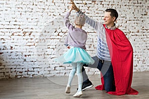 Happy father in superhero costume and his daughter photo