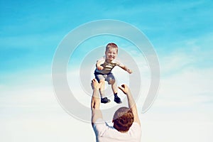 Happy father throws son child into the air,