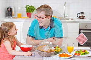 Happy father withpretty daughter having fun breakfast