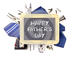 Happy Fathers Day chalkboard with underlying frame of tools and ties isolated on white