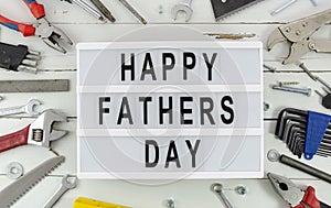 Happy Fathers Day concept flat lay with a border of tools on a rustic wood background