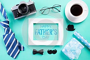 Happy fathers day concept. Top view of blue tie, beautiful gift box, black coffee cup, white picture frame with Happy father`s da