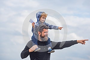 Happy fathers day. Dad and son are playing on sky background. Father and son building together a paper airplane