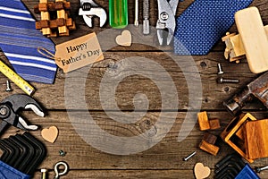 Happy Fathers Day gift tag with frame of gifts, ties and tools on a wood background