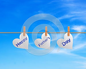 Happy Fathers Day Hanging In Heart Blue Sky Background. Words in pegs on a Rope. Father`s day Greeting Creative Idea.