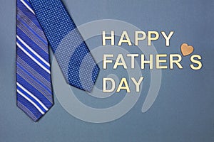 Happy Fathers Day message with blue neck ties over a grey blue paper background
