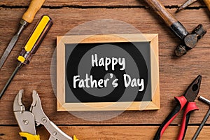 Happy Fathers Day text with side border of tools and ties on a rustic wood background