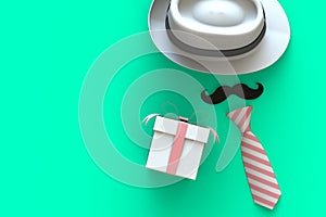 Happy Fatherâ€™s Day concept with gift box, mustache and neck tie on green background, Top view with copy space