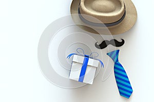Happy Fatherâ€™s Day concept with gift box, mustache and neck tie on white background, Top view with copy space
