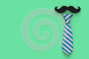 Happy Fatherâ€™s Day concept with mustache and neck tie on green background, Top view with copy space