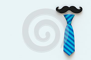 Happy Fatherâ€™s Day concept with mustache and neck tie on white background, Top view with copy space.