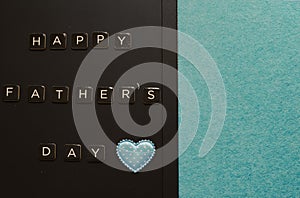 Happy fatherâ€™s day greetings on blackboard decorated with blue heart