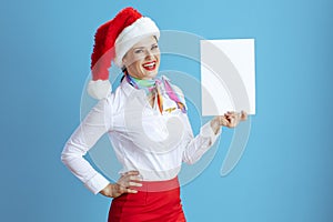 happy female air hostess on blue showing blank a4 paper sheet