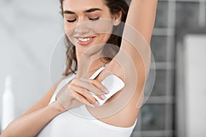 Happy Female Applying Antiperspirant Stick Underarms In Bathroom Indoor