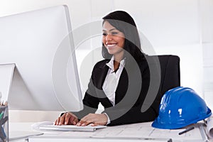 Happy female architect using computer