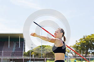 Happy female athlete about to throw a javelin