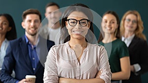 Happy female business leader standing in front of team