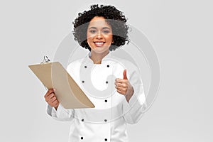 happy female chef with clipboard showing thumbs up